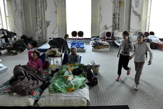 Begunci po begu iz Ukrajine v Romunijo počivajo v plesni dvorani, ki je bila preurejena v začasno zatočišče. FOTO: Clodagh Kilcoyne/Reuters

