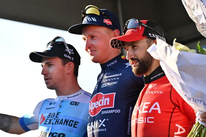 Tim Merlier (v sredini) na stopničkah med Nizozemcem&nbsp;Dylanom Groenewegnom (levo) in&nbsp;Francozom Nacerjem Bouhannijem.&nbsp;FOTO: Dirk Waem/AFP

