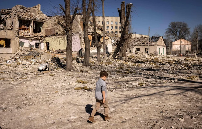 Otrok hodi mimo popolnoma uničene šole v mestu Žitomir na severu Ukrajine, ki jo je obiskoval pred začetkom ruske invazije. Foto: Fadel Senna/Afp
