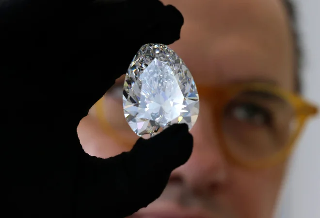 V dražbeni hiši Christie's v Dubaju je na ogled velikanski diamant z vzdevkom »The Rock«. 228,31-karatni dragulj hruškaste oblike, ki so ga pred več kot 20 leti izkopali in obrusili v Južni Afriki, je največji beli diamant, ki je kdajkoli prišel na dražbo. Po Dubaju, kjer bo razstavljen od 26. do 29. marca, bo »The Rock« potoval v Tajpej, New York in Ženevo, kjer naj bi na dražbi 11. maja zanj iztržili do 30 milijonov dolarjev. Foto: Karim Sahib/Afp