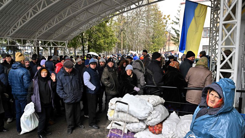 Fotografija: Prebivalci Buče čakajo na pomoč. FOTO: Sergei Supinsky/Afp
