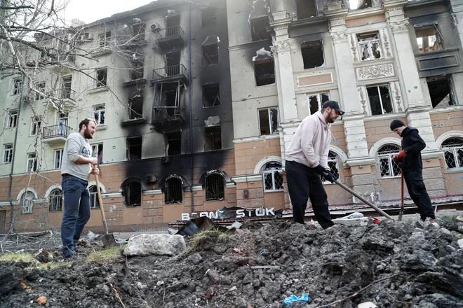 Pogreb prebivalca Mariupolja v obleganem mestu. FOTO: Alexander Ermochenko/Reuters
