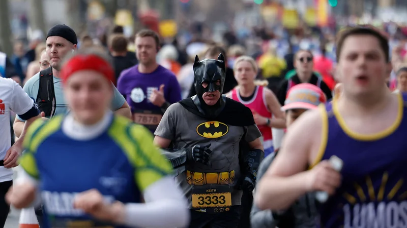 Tekač, oblečen v Batmana, tekmuje na polmaratonu London Landmarks 2022. Foto: Tolga Akmen/Afp
