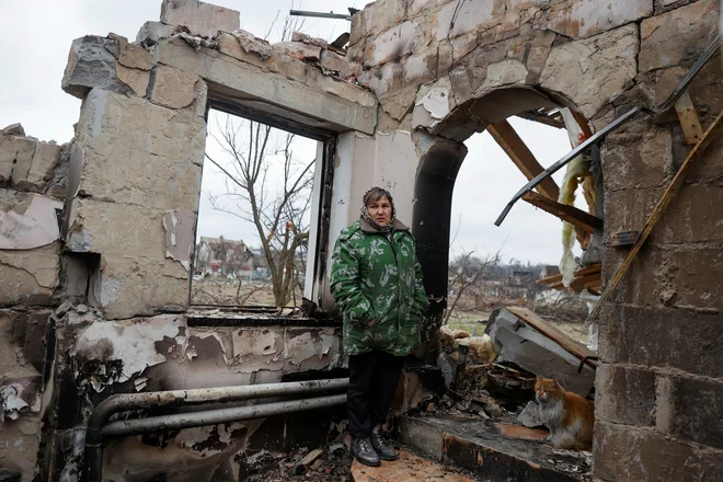 Ženska med ruševinami svoje hiše v Černigovu. FOTO: Serhii Nuzhnenko/Reuters
