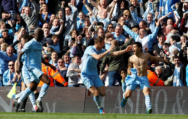 Gol Sergia Agüera (desno) je povzročil eksplozijo navdušenja na štadionu Etihad, medtem ko je na razplet tekme v Sunderlandu čakal mestni tekmec Manchester United, ki bi v primeru remija med Cityjem in QPR osvojil naslov. FOTO: Darren Staples/Reuters
