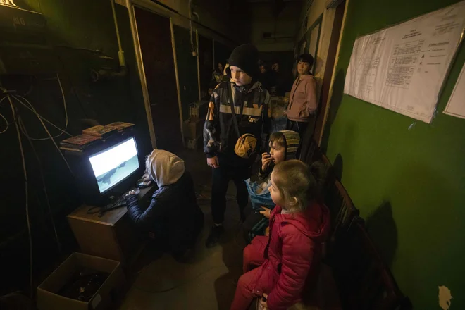 Otroci gledajo risanko, medtem ko se odrasli zbirajo v zaklonišču v mestu Severodoneck, v ukrajinski regiji Donbas. Ruska vojska se je zdaj osredotočila na vzhod Ukrajine, ukrajinske oblasti v Lugansku in Donecku pa opozarjajo, da bi morali civilisti zapustiti območje, »dokler je še priložnost«. Obsežen ruski vojaški napad pričakujejo v prihodnjih dneh, ko bodo ruske enote, ki so se umaknilew iz okolice Kijeva, prišle v Donbas oziroma še dlje. Nato meni, da želi Moskva prevzeti nadzor nad celotno regijo Donbas na vzhodu Ukrajine, da bi ustvarila koridor iz Rusije do Krima. Foto: Fadel Senna/Afp