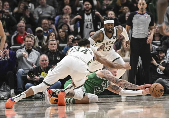 Boston center Daniel Theis je bil v objemu Milwaukeejevih mož Giannisa Antetokounmpa in Wesleyja Matthewsa v izgubljenem položaju. FOTO: Benny Sieu/Usa Today Sports
