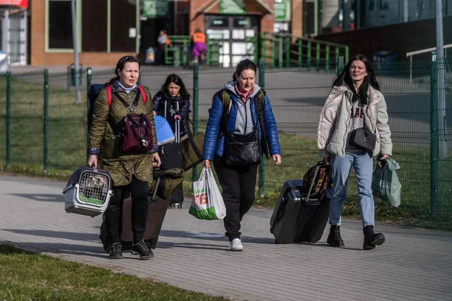 Ukrajinski begunci na poljsko-ukrajinski meji. FOTO: Wojtek Radwanski/AFP
