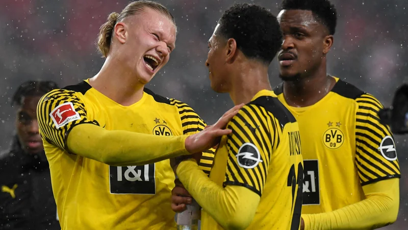 Fotografija: Erling Haaland (levo) v sproščenem pogovoru z angleškim soigralcem Judom Bellinghamom po zadnjem sodnikovem žvižgu. FOTO: Thomas Kienzle/AFP