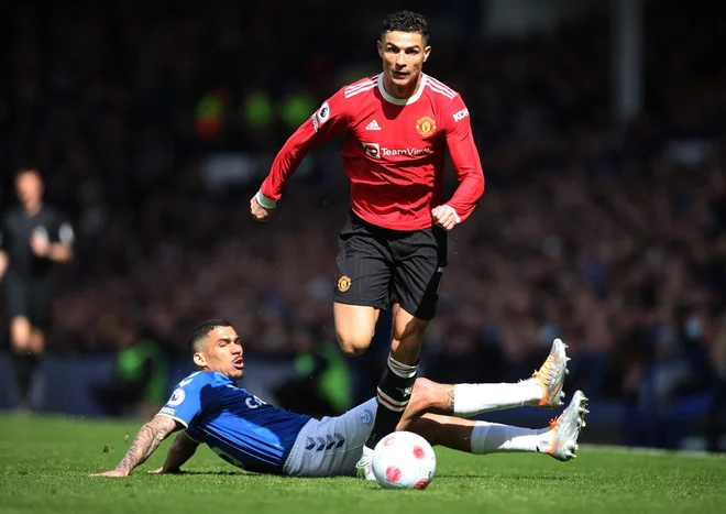 Cristiano Ronaldo prodira ob vezistu Evertona, Brazilcu Allanu, na štadionu Goodison Park. FOTO: Phil Noble/Reuters
