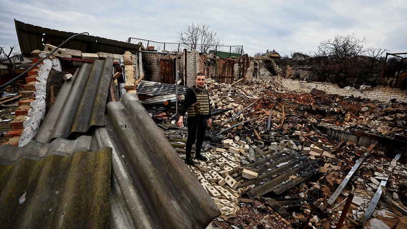 Fotografija: 32-letni humanitarni delavec Oleksandr Markov med ruševinami hiše svojih staršev v Černigovu. FOTO: Zohra Bensemra/Reuters

