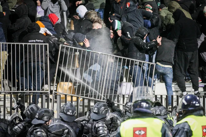 Enega od policistov po nogometnem derbiju odpeljali v bolnišnico. FOTO: Marko Pigac