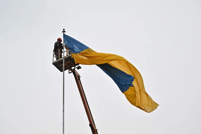 Postavljanje ukrajinske zastave v središču Makariva v kijevski regiji. FOTO: Sergei Supinsky/AFP