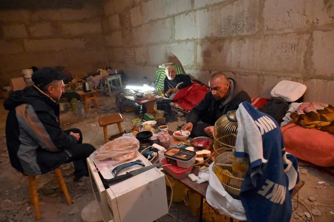 Življenje v zaklonišču v kletnih prostorih večnadstropne stavbe v Harkovu. FOTO: Sergey Bobok/AFP