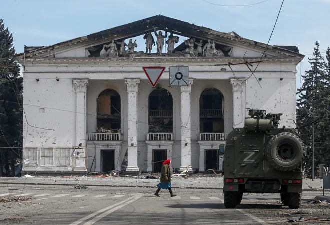 Oklepnik proruskih sil pred uničenim gledališčem v Mariupolju. FOTO: Alexander Ermochenko/Reuters