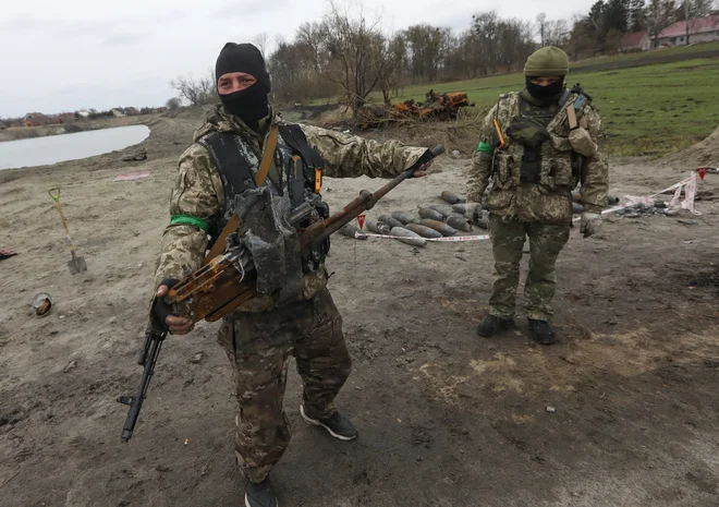 Ukrajinska vojaka z mitraljezom z uničenega ruskega tanka. FOTO: Reuters