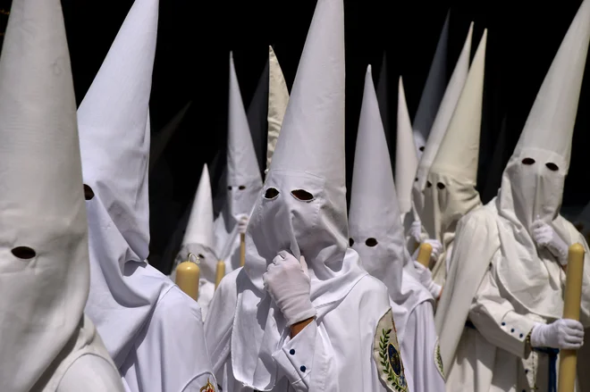 Kesanci bratovščine La Paz na procesiji na cvetno nedeljo v Sevilli. Krščanski verniki po vsem svetu obeležujejo verski teden pred veliko nočjo, ko praznujejo križanje in vstajenje Jezusa Kristusa. Foto: Cristina Quicler/Afp