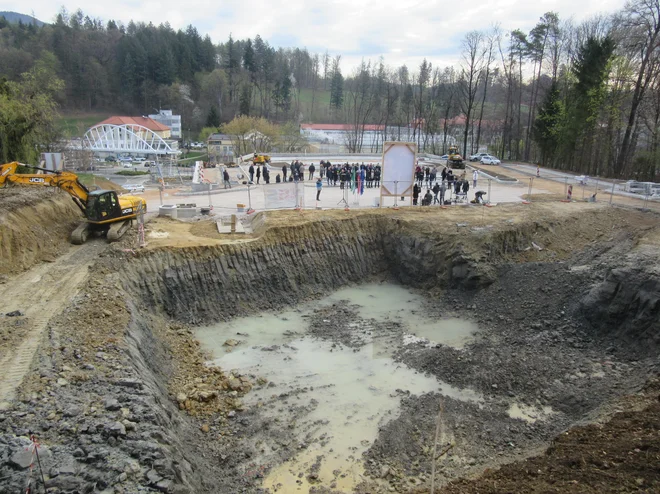 Velika gradbena jama na Tržaškem hribu je pripravljena za začetek gradnje razglednega stolpa Kristal. V ozadju že stoji nadhod Sonce, prav tako urejajo parkirišče P+R. FOTO: Špela Kuralt/Delo

