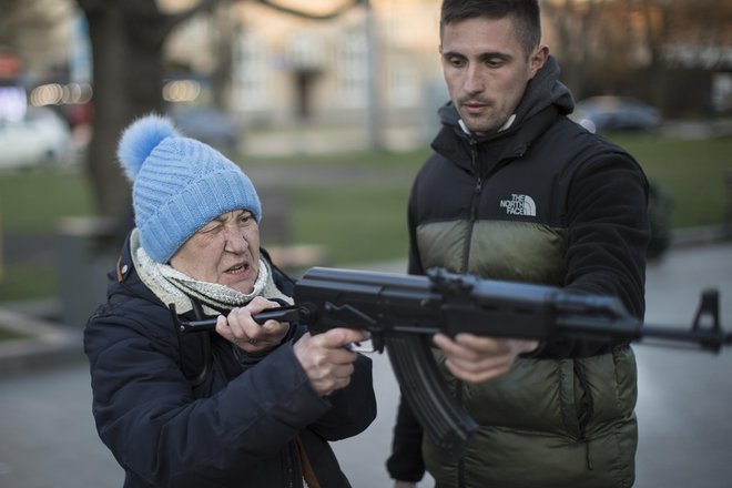 Na Trgu kralja Danila mimoidoči s plastično kalašnikovko streljajo v tarčo s podobo Vladimirja Putina. FOTO: Jure Eržen/Delo
