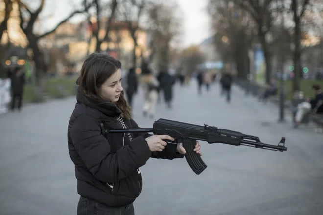 Na Trgu kralja Danila mimoidoči s plastično kalašnikovko streljajo v tarčo s podobo Vladimirja Putina. FOTO: Jure Eržen/Delo
