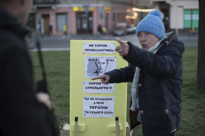 Na Trgu kralja Danila mimoidoči s plastično kalašnikovko streljajo v tarčo s podobo Vladimirja Putina. FOTO: Jure Eržen/Delo
