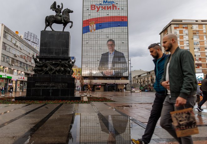 Ljudje hodijo mimo ogromnega oglasnega panoja volilne kampanje Aleksandra Vučića na hotelu Ambasador. FOTO: Antonio Bronic/ Reuters
