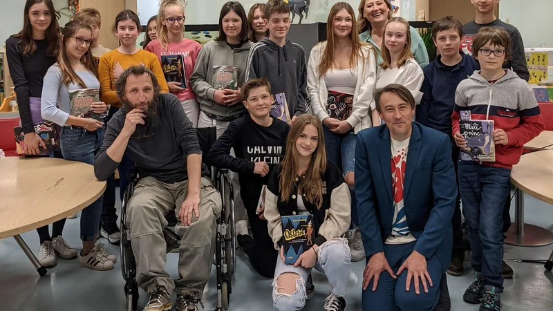 Fotografija: Mladi bralci iz OŠ Vižmarje Brod s programskim direktorjem Beletrine Alešem Štegrom, likovnim urednikom Damijanom Stepančičem in urednico zbirke, njihovo učiteljico Anito Dernovšek. FOTO: Beletrina