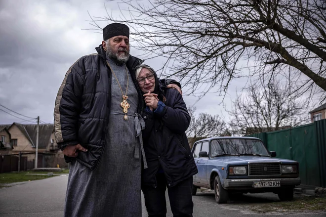 Prebivalci Hostomlja žalujejo za sosedi, ki so jih pobile ruske enote. FOTO: Fadel Senna/AFP
