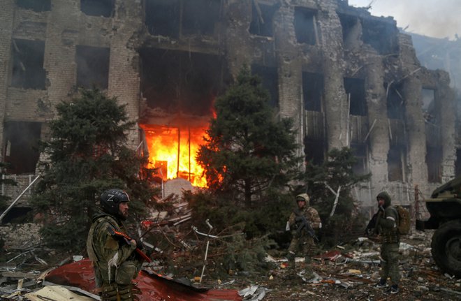 Ruski borci pred gorečim poslopjem tovarne Azovstal. FOTO:  Chingis Kondarov/Reuters
