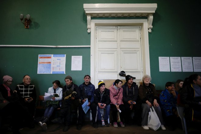Ukrajinski begunci čakajo, da zberejo pomoč in se registrirajo v centru za notranje razseljene ljudi v mestu Krivij Rih v regiji Dnepropetrovsk. FOTO: Ueslei Marcelino/Reuters
