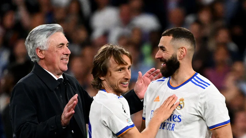 Fotografija: Carlo Ancelotti in njegova aduta Luka Modrić ter Karim Benzema. FOTO: Gabriel Bouys/AFP