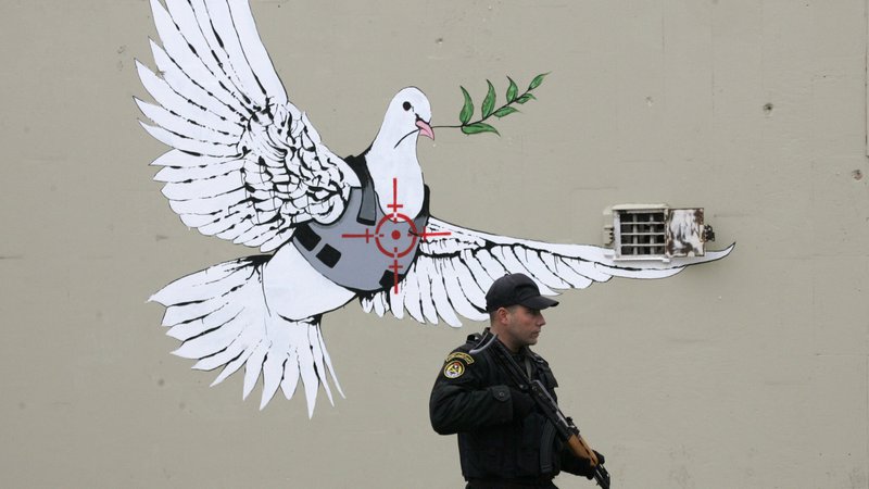Fotografija: Poslikal je tudi dele nezakonitega betonskega zidu na Zahodnem bregu. FOTO: Nayef Hashlamoun/Reuters
