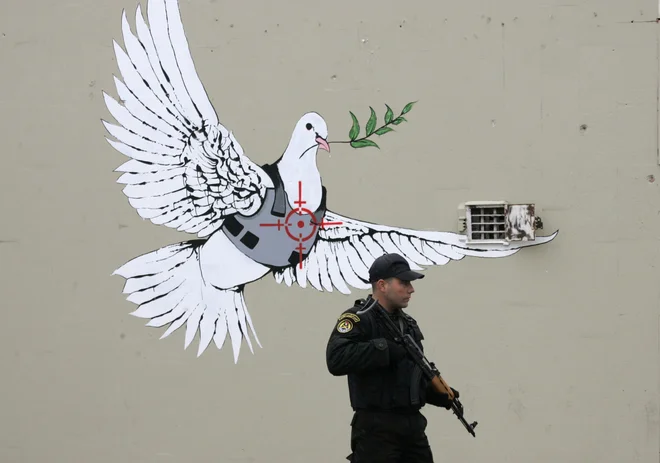 Poslikal je tudi dele nezakonitega betonskega zidu na Zahodnem bregu. FOTO: Nayef Hashlamoun/Reuters
