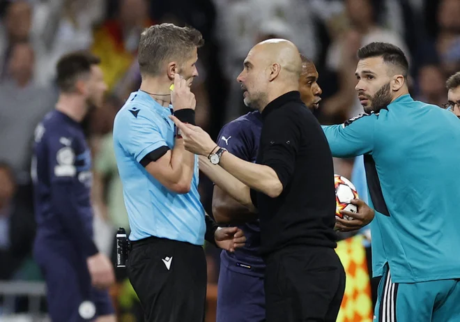 Italijanski sodnik Daniele Orsato v pogovoru s trenerjem Man. Cityja Pepom Guardiolo na povratni tekmi polfinala lige prvakov v Madridu. FOTO: Juan Medina/Reuters
