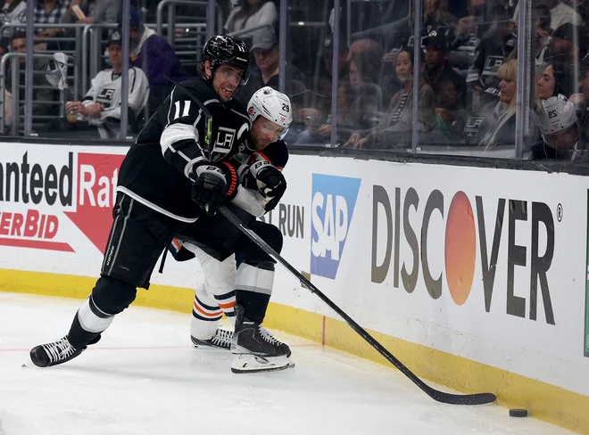 Anže Kopitar (št. 11) in Leon Draisaitl v ostrem dvoboju. FOTO: Harry How/AFP
