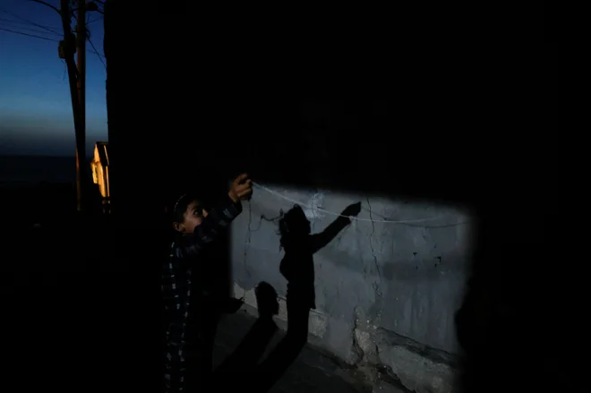 Palestinska deklica med igro pred družinsko hišo v begunskem taborišču Deir al-Balah v Gazi. Foto: Mohammed Salem/Reuters