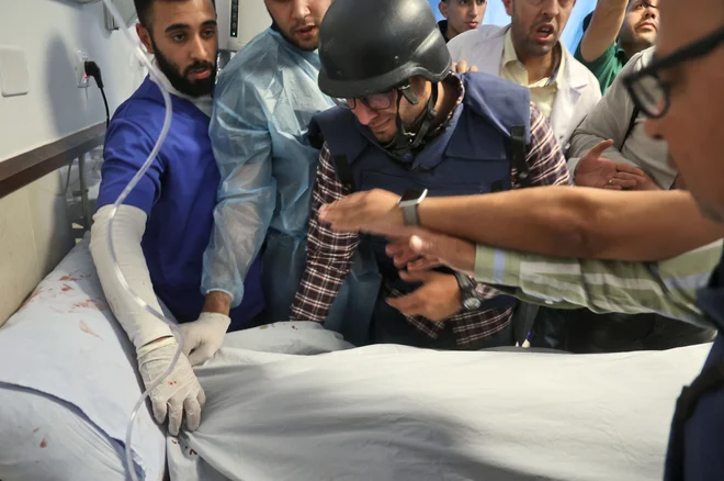 Novinarski kolegi okoli trupla Širin Abu Akleh. FOTO: Jaafar Ashtiyeh/AFP
