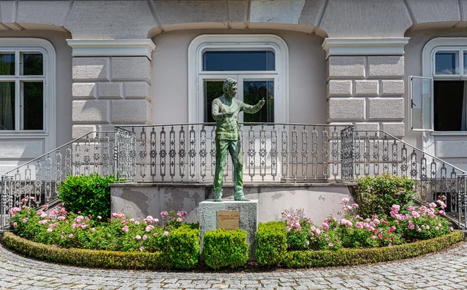 Kip dirigenta Herberta von Karajana obiskovalce pozdravlja z vrta njegove rojstne hiše, od koder se odpira lep pogled na Salzburg. FOTO: Shutterstock
