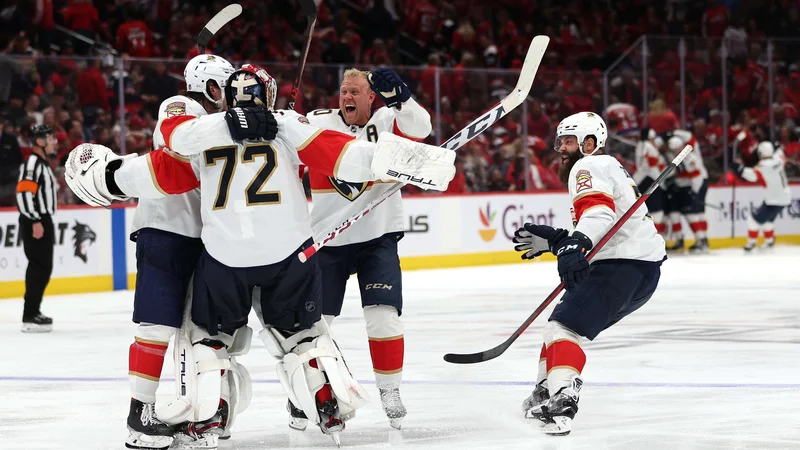 Fotografija: Floridski hokejisti slavijo z vratarjem Sergejem Bobrovskim po odločilnem zadetku v podaljšku šeste tekme v washingtonski dvorani Capital One Arena. FOTO: Patrick Smith/AFP