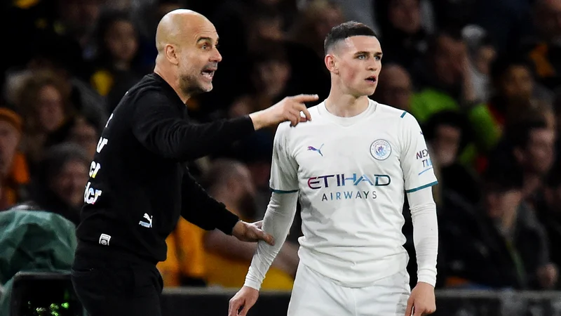 Fotografija: Pep Guardiola in Phil Foden med tekmo v Wolverhamptonu, kjer je City slavil s 5:1, kar štiri gole je prispeval vezist Kevin De Bruyne. FOTO: Peter Powell/Reuters