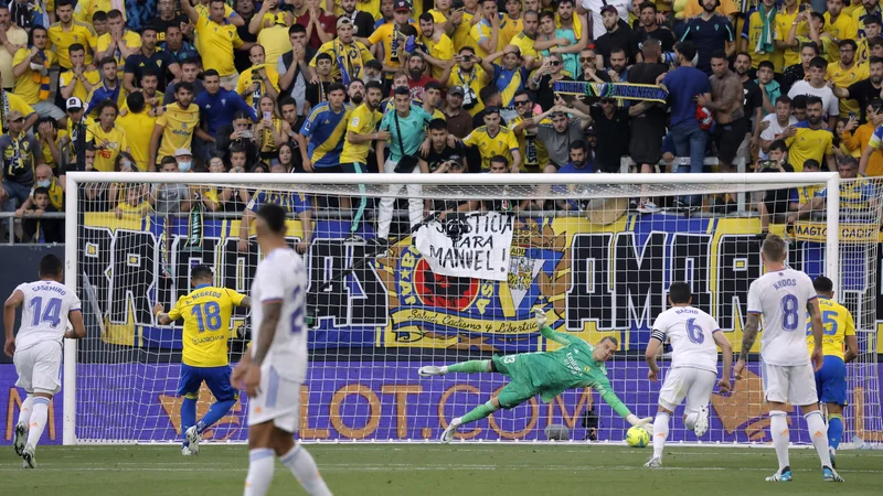 Fotografija: Ukrajinski vratar madridskega Reala Andrij Lunin je spet dobil priložnost pred belgijskim zvezdnikom Thibautom Courtoisom in se izkazal z ubranjeno 11-metrovko Alvaru Negredu. FOTO: Jon Nazca/Reuters
