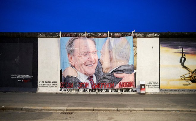 Grafit ruskega predsednika Vladimirja Putina in nekdanjega nemškega kanclerja Gerharda Schröderja v galeriji East Side v Berlinu. Na grafitu je napis: Moj bog, pomagaj mi preživeti to smrtonosno ljubezen. Foto Anne Barth/Reuters
