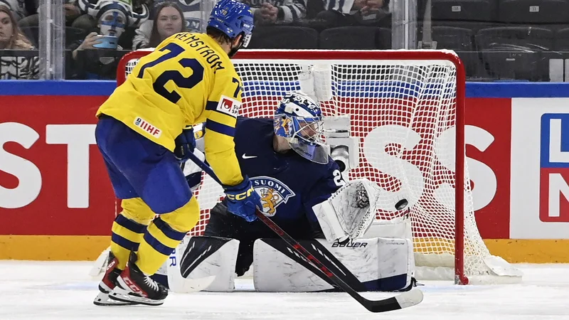 Fotografija: Strelec zmagovitega gola Emil Bemstrom in finski vratar Harri Sateri. FOTO: Heikki Saukkomaa/AFP