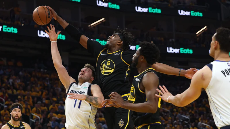 Fotografija: Kevon Looney ustavlja Luko Dončića na prvi tekmi v dvorani Chase Center. FOTO: Harry How/AFP