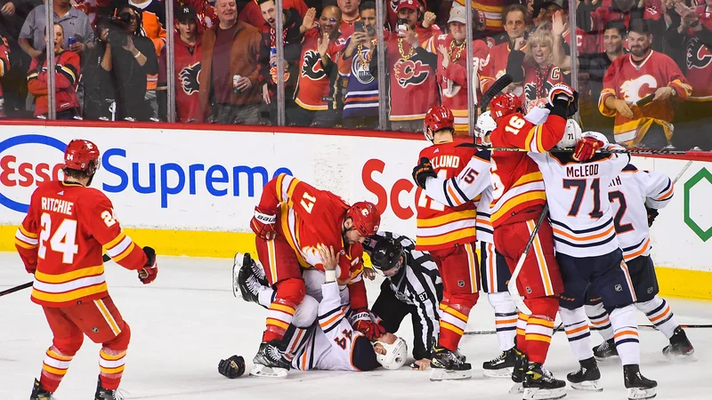 Fotografija: Milan Lučić (zgoraj) se je v zadnji tretjini takole lotil Zacka Kassiana v domači dvorani Scotiabank Saddledome v Calgaryju. FOTO: Derek Leung/AFP
