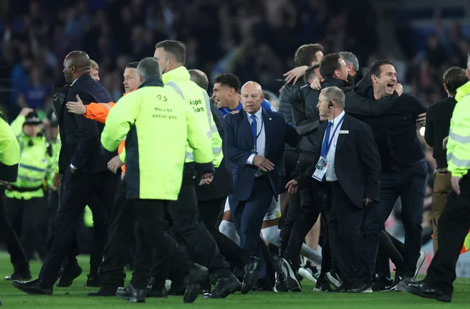 Trener Liverpoolčanov Frank Lampard proslavlja po odločilni zmagi, ki je Evertonu vendarle zagotovila obstanek med elito. Patrick Vieira (levo) se je podal proti slačilnicam, ki pa so na štadionu Goodison Park na drugi strani zelenice ...&nbsp;FOTO: Carl Recine/Reuters

