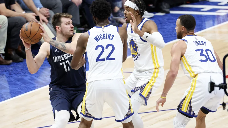 Fotografija: Luka Dončić prodira ob Andrewu Wigginsu, Mosesu Moodyju in Stephenu Curryju (z leve). FOTO: Kevin Jairaj/USA Today Sports