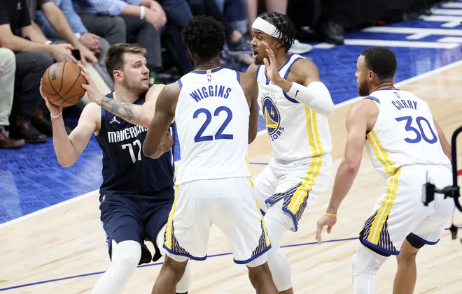 Luka Dončić prodira ob Andrewu Wigginsu, Mosesu Moodyju in&nbsp;Stephenu Curryju (z leve). FOTO:&nbsp;Kevin Jairaj/USA Today Sports
