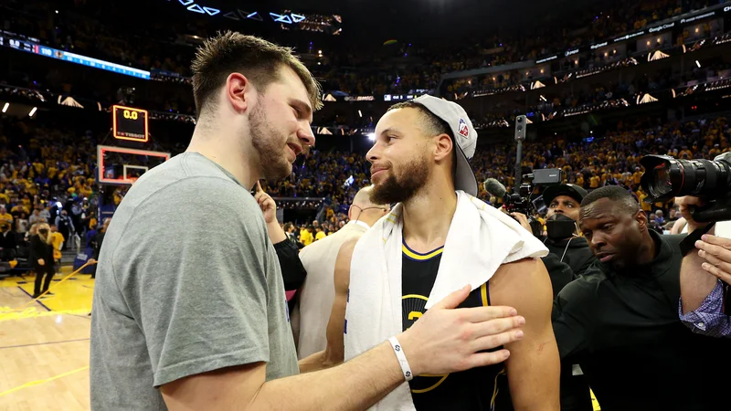 Fotografija: Luko Dončića je po odločilnem porazu tolažil tudi MVP finala zahodne konference Stephen Curry (desno). FOTO: Ezra Shaw/AFP