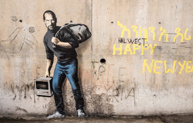 Na enem od grafitov, ki naj bi jih ustvaril, je Banksy v zloglasnem nekdanjem nezakonitem begunskem taboru Džungla v Calaisu na severu Francije leta 2015 upodobil pokojnega milijarderskega ustanovitelja podjetja Apple Steva Jobsa kot begunca. FOTO: Philippe Huguen/AFP
